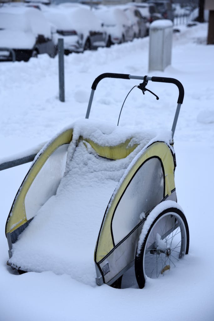 A snow-covered bicycle trailer on a snowy street in Hannover, Germany.