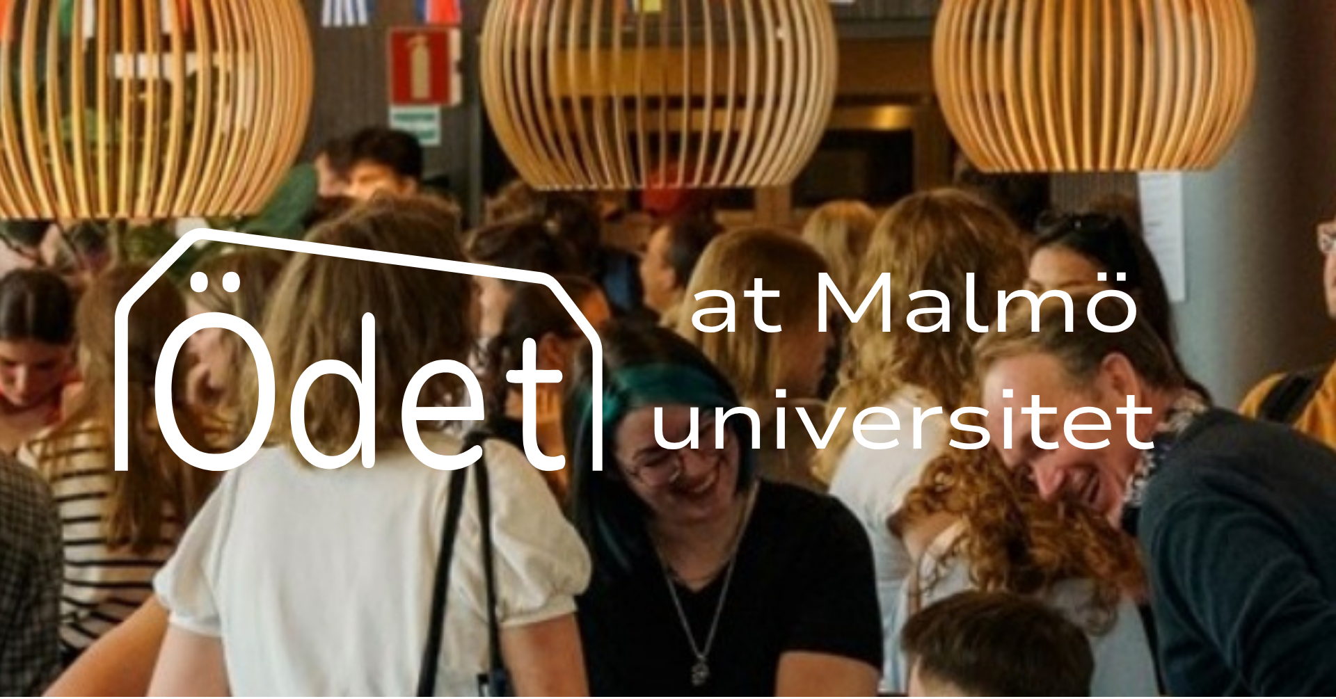 Människor som minglar och pratar i en lokal med runda trälampor i taket, med texten 'Ödet at Malmö universitet' på bilden.
